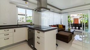 Una cocina moderna con lavavajillas, un comedor con mesa y sillas, y una sala de estar con sofá.