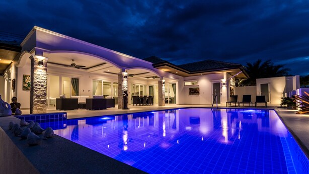 A modern house with a swimming pool, outdoor seating, and a patio area. - Orchid Paradise Homes OPV313 (Hua Hin)