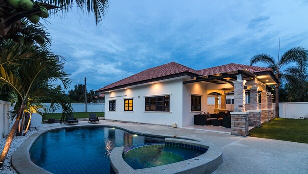 A modern house with a swimming pool, outdoor seating, and a covered patio. - Orchid Paradise Homes OPV22 (Hua Hin)