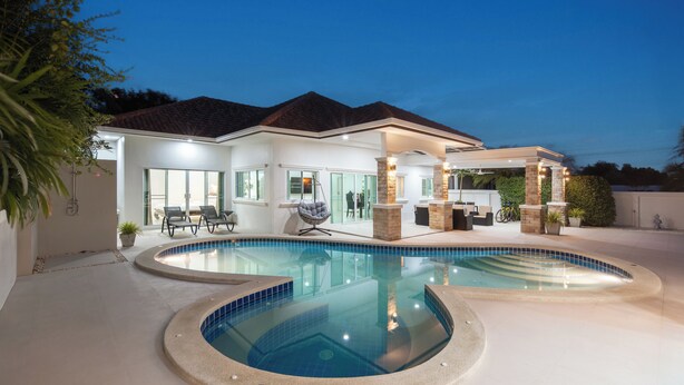 A modern house with a large swimming pool, outdoor seating area, and a covered patio. - Orchid Paradise Homes OPV02 (Hua Hin)