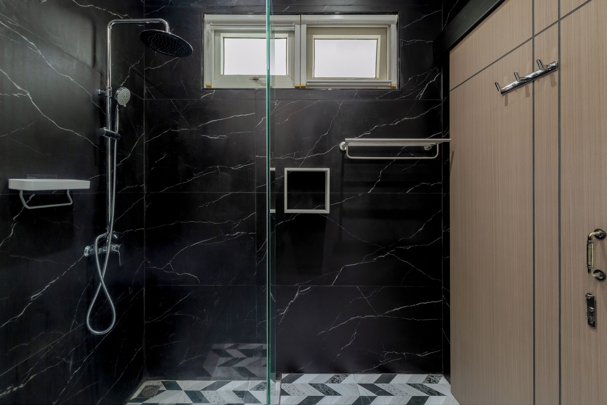 Une salle de bain moderne avec une douche à parois de verre, une petite fenêtre et un placard en bois.