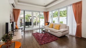 A modern living room with a sofa, a coffee table, and a TV.