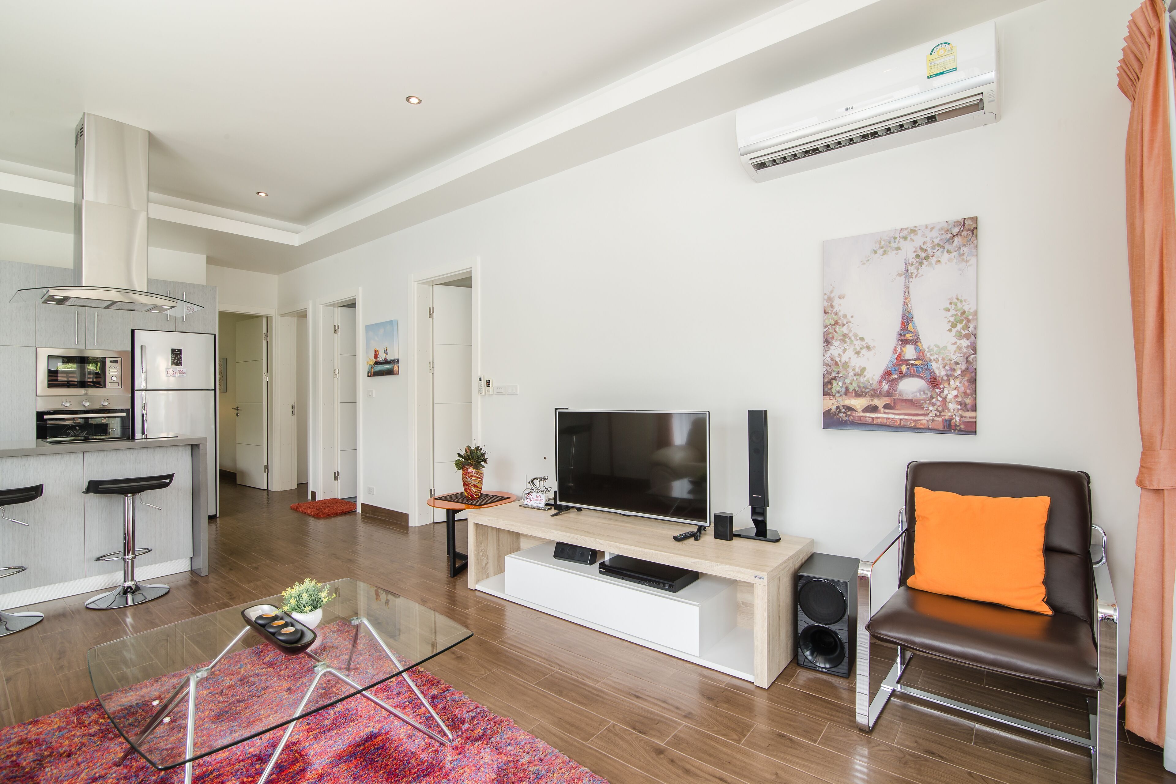 Un soggiorno moderno con TV, diffusori e una poltrona confortevole.