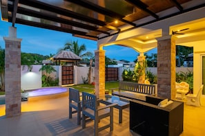 An outdoor patio area with a pool, seating, and a gazebo.