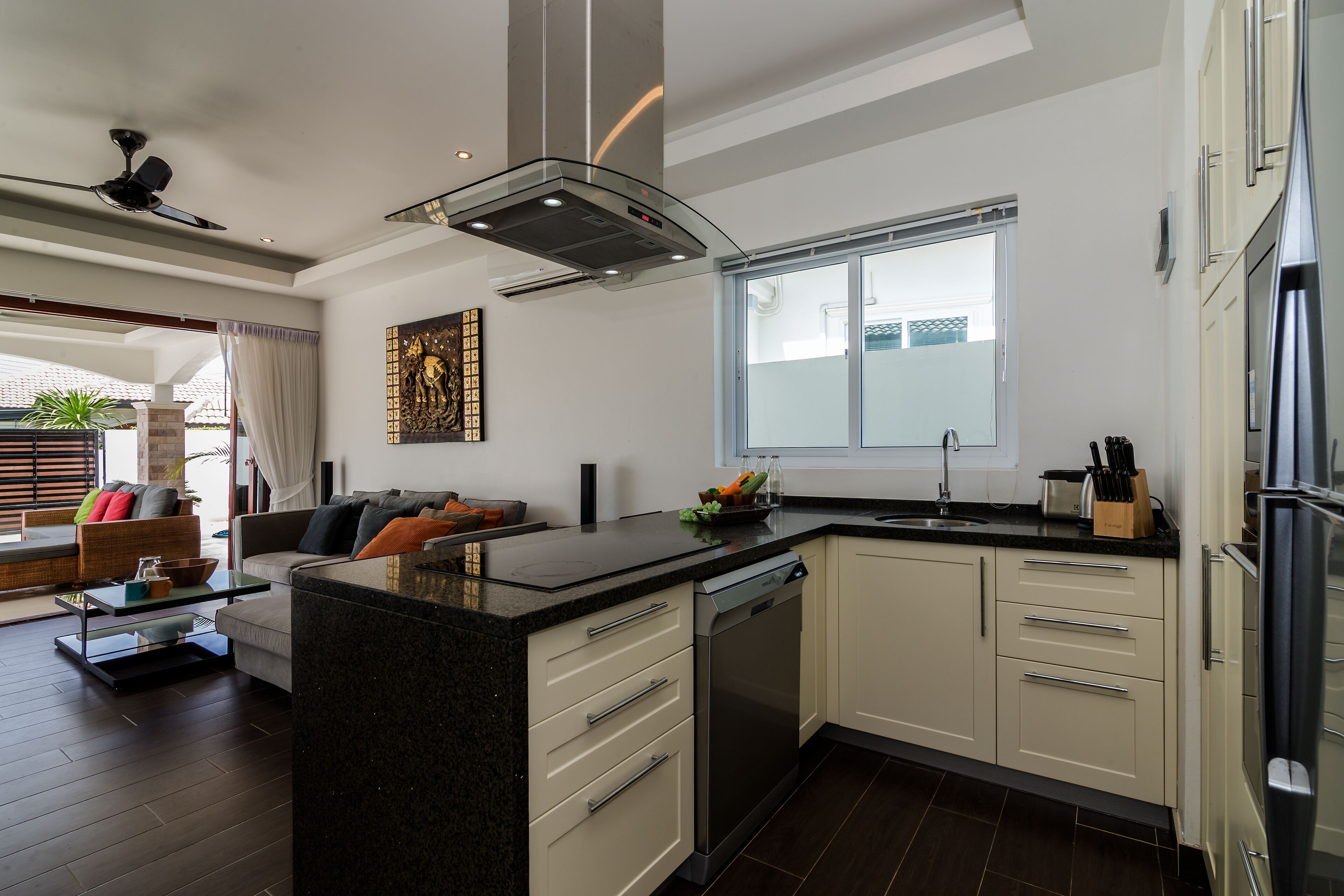 A modern kitchen with a central island, built-in dishwasher, and stainless steel appliances.