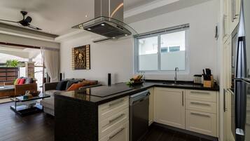 A modern kitchen with a central island, built-in dishwasher, and stainless steel appliances.