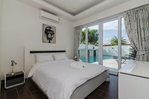 Une chambre moderne avec un grand lit, une vue sur une piscine et un ventilateur de plafond.