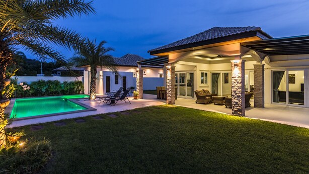 A modern house with a swimming pool, outdoor seating, and a covered patio area. - Orchid Paradise Homes OPV220 (Hua Hin)