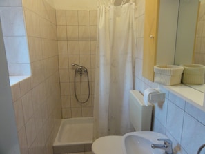 Ein Badezimmer mit Dusche, Toilette und Waschbecken.