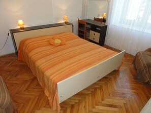 Ein Schlafzimmer mit einem Bett, einem Schreibtisch und einem Stuhl.