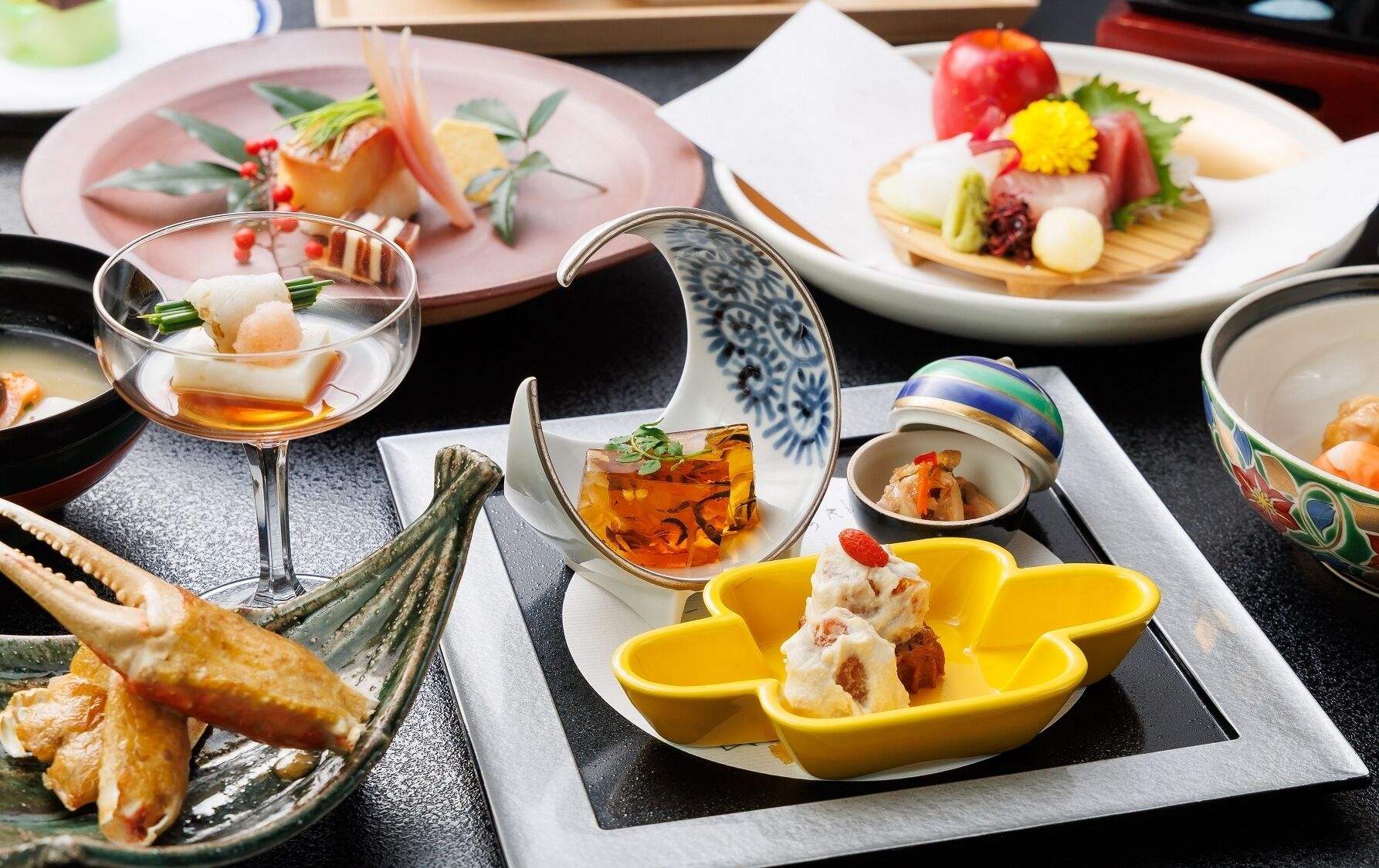 A variety of dishes on a table, including seafood, vegetables, and a dessert.