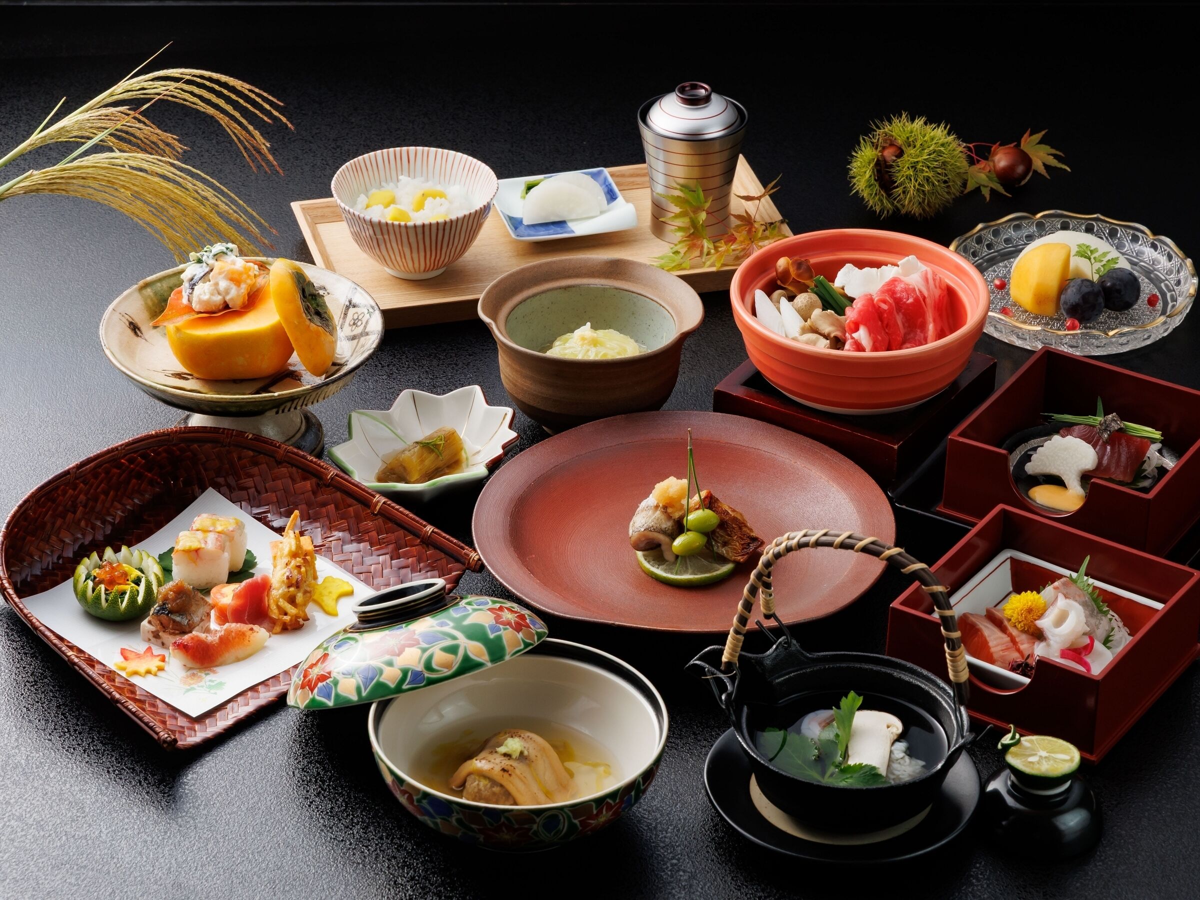 A variety of Japanese dishes arranged on a table, including sushi, sashimi, and other traditional foods.