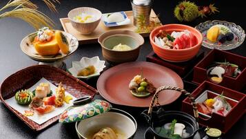 A variety of Japanese dishes arranged on a table, including sushi, sashimi, and other traditional foods.