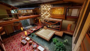 A traditional Japanese-style interior with tatami flooring, low wooden furniture, and a hanging light fixture.