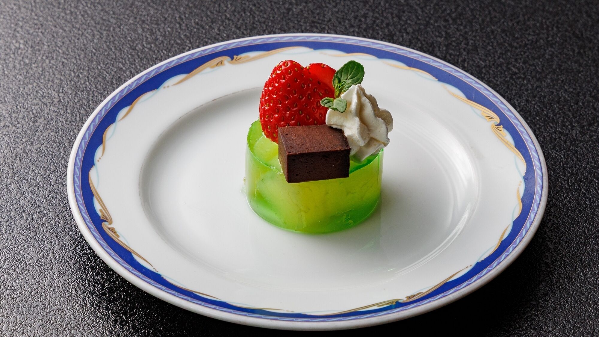 A dessert on a plate with a blue and gold rim.
