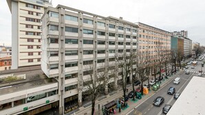 Un edificio de varios pisos con un estilo arquitectónico moderno, que presenta una fachada plana y ventanas amplias.