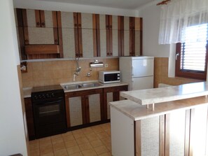 Apartamento, 2 quartos (N2) | Cozinha privada | Geladeira, micro-ondas, cooktop, talheres/pratos/utensílios de cozinha