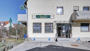 Entrada de hotel com uma placa que diz "Austible Hotel & Restaurant" e uma placa de estacionamento.