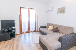 Appartement, 2 chambres | Salle de séjour | Télévision à écran plat