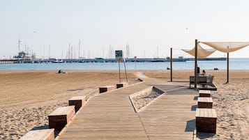 En la playa, playa de arena blanca, camastros y sombrillas