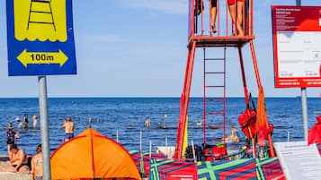 On the beach, white sand, sun-loungers, beach umbrellas