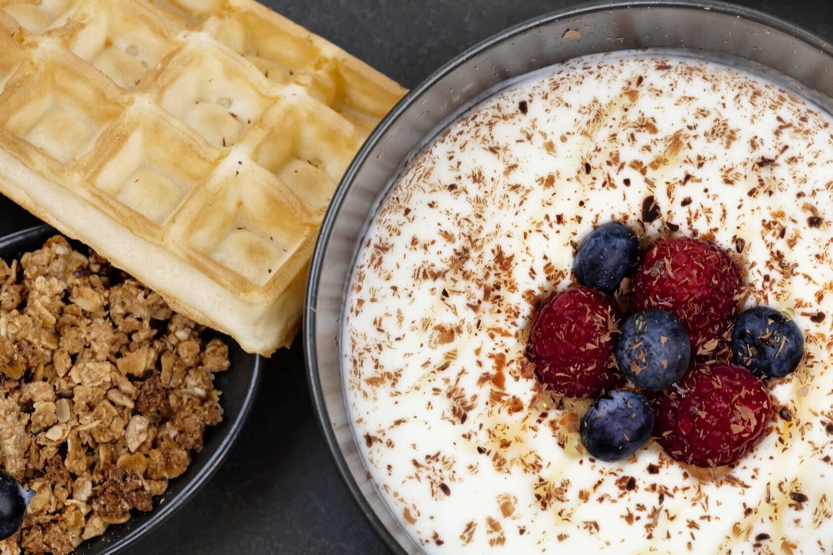 Wafel, granola en yoghurt met bessen.