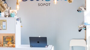 A room with a white desk, a laptop, a plush toy, and a wall with the text "Seaside SOPOT". - SeaSide Sopot (Sopot)