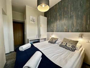 A hotel room with a bed, a desk, and a wardrobe. - SeaSide Sopot (Sopot)