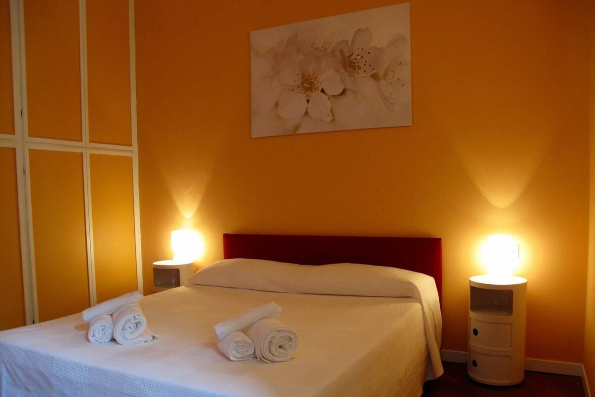 Ein Hotelzimmer mit einem Bett, zwei Nachttischlampen und einem Bild an der Wand.