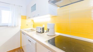Una cocina equipada con lavavajillas, tostadora, cafetera y estufa.