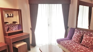 A room with a sofa, a small table, a mirror, and a window with curtains. - Seaview Floor 11 Jomtien Beach (Pattaya)