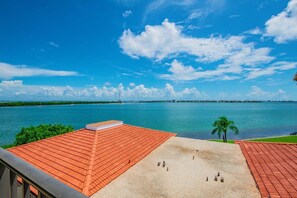Una terraza en la azotea con vista al mar tranquilo y un cielo despejado.
