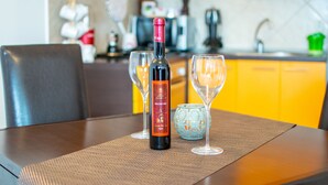 Una mesa con una botella de vino, dos copas de vino y un cuenco decorativo.