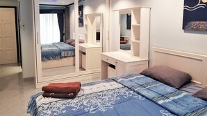 A bedroom with a bed, a mirror, a dresser, and a wardrobe. - Floor 12 Jomtien Beach Condo (Pattaya)