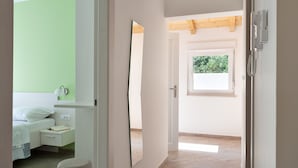 A bedroom with a bed, bedside table, and a mirror. - Holiday Home Hana (Medulin)