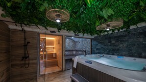 Un cuarto de spa con piso de madera, un jacuzzi y una puerta de vidrio que da a una sauna.