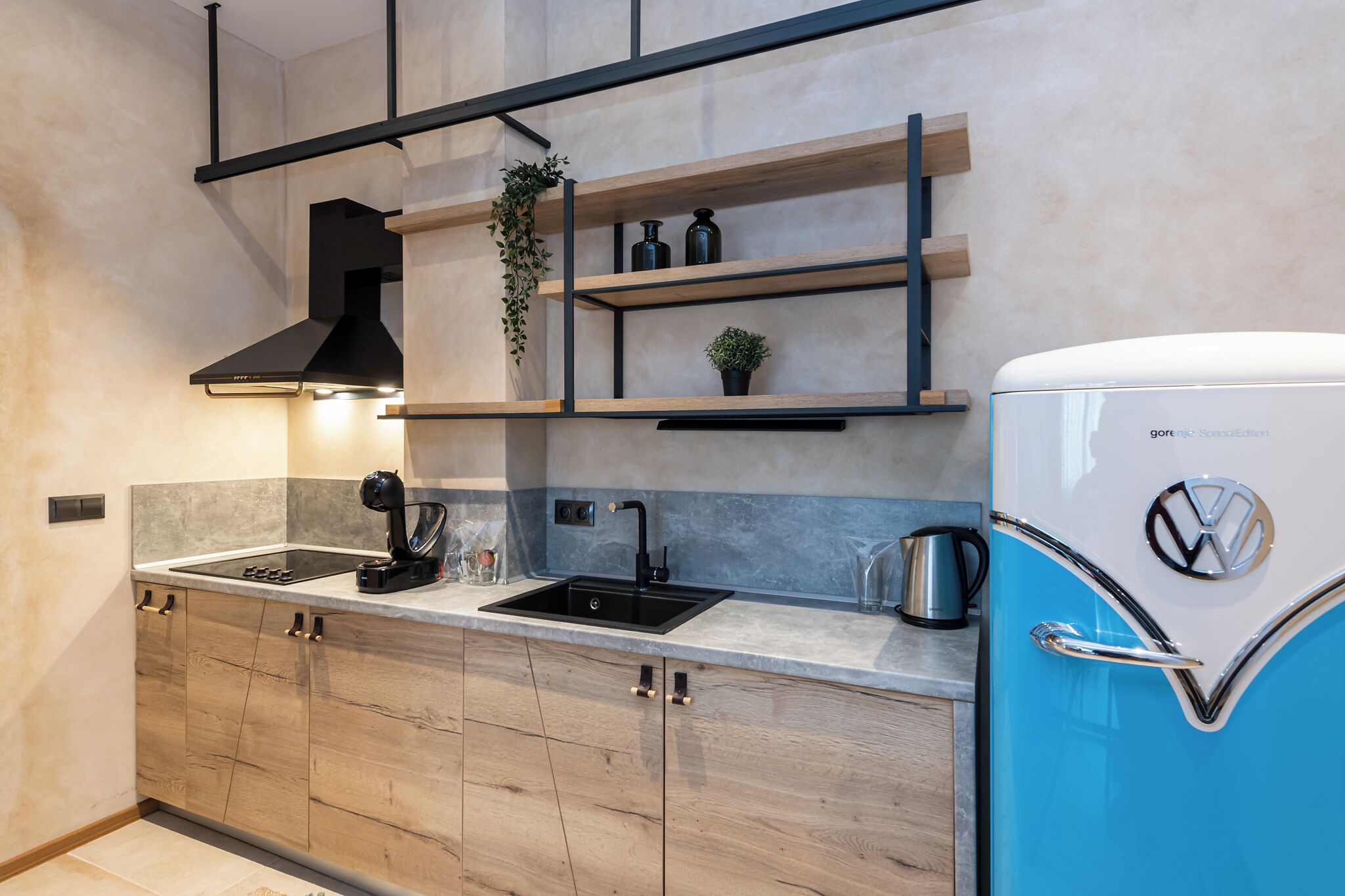A modern kitchen with a built-in stove, a sink, and a vintage refrigerator.