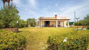 A house with a patio, outdoor furniture, and a well-maintained lawn. - Garden Chich (Noto)
