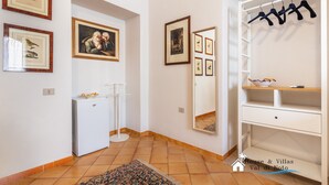 A hallway with a white wardrobe, a mirror, and framed pictures on the wall. - Liberty Guest House (Avola)