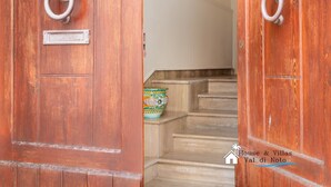 A wooden door with a metal ring handle and a nameplate. - Liberty Guest House (Avola)