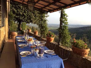 A long table set for dining with a view of the countryside. - Tuscany Villa With Breathtaking View (Civitella in Val di Chiana)