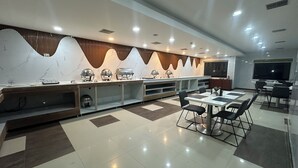 Una cocina moderna con salpicadero de mármol, electrodomésticos integrados y comedor con un amplio ventanal.