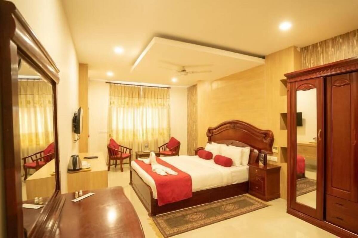 Une chambre d’hôtel comprenant un lit, une armoire, un bureau, une chaise et un miroir.