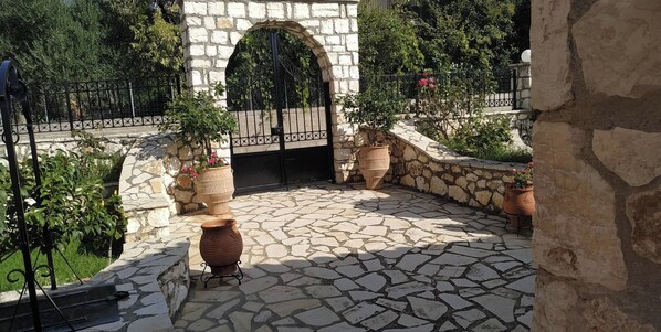 Stroll through the traditional courtyard, surrounded by lush potted plants and a stone archway.