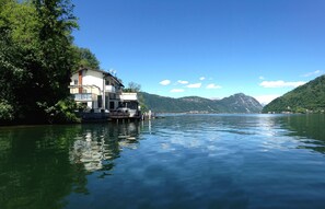 A lakeside house with a dock, surrounded by lush greenery and mountains. - Direct on Lugano Lake: Take a Swim From Your Villa (Riva San Vitale)