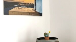 A wooden barrel with a potted cactus on top, placed against a white wall.