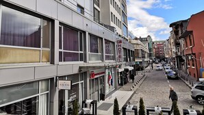Um hotel com fachada moderna, grandes janelas e a placa do hotel visível.