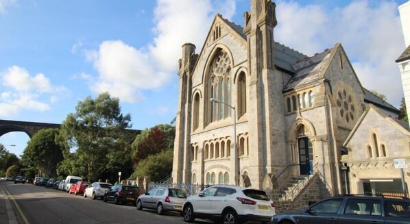 A historic stone building with arched windows and a prominent entrance.