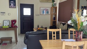 Un soggiorno con divano, un tavolo da pranzo con sedie, un lampadario, un orologio e un cartello 'No Smoking'.