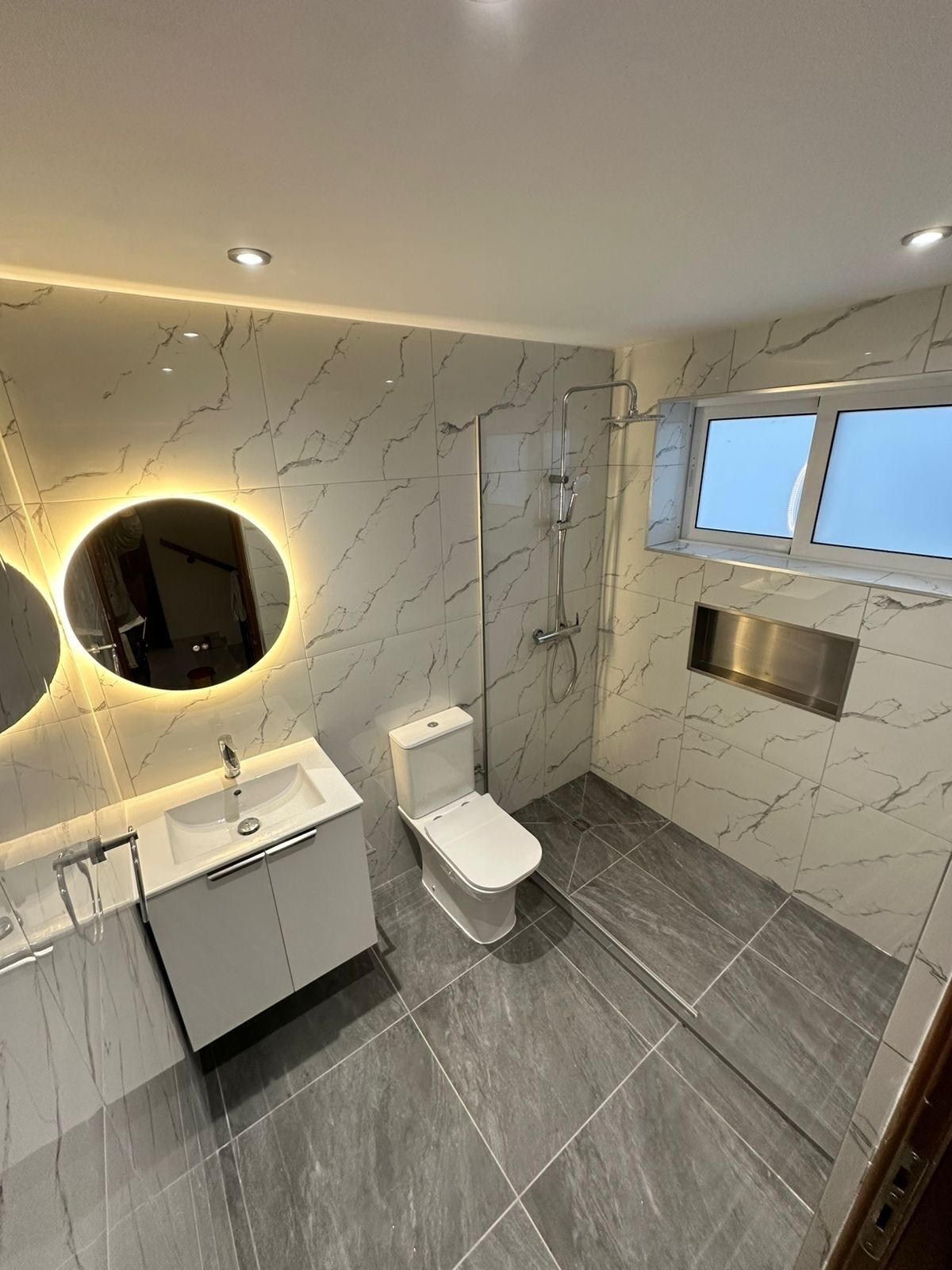 Een bad/douchecombinatie, een haardroger, handdoeken, toiletpapier